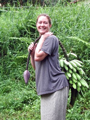 Lisa cuts down her first banana tree with a machette