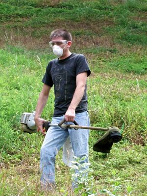 Me weed wacking the yard, the yard is so steep i had do wear metal spike cleats to do yard work